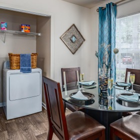 a dining room with table chairs and washer and dryer in a closet