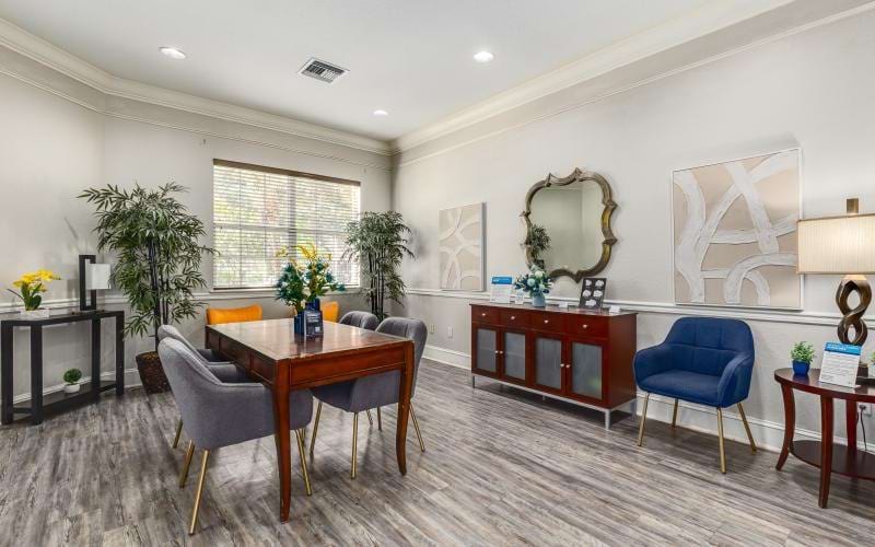 a room with a table chairs and a mirror