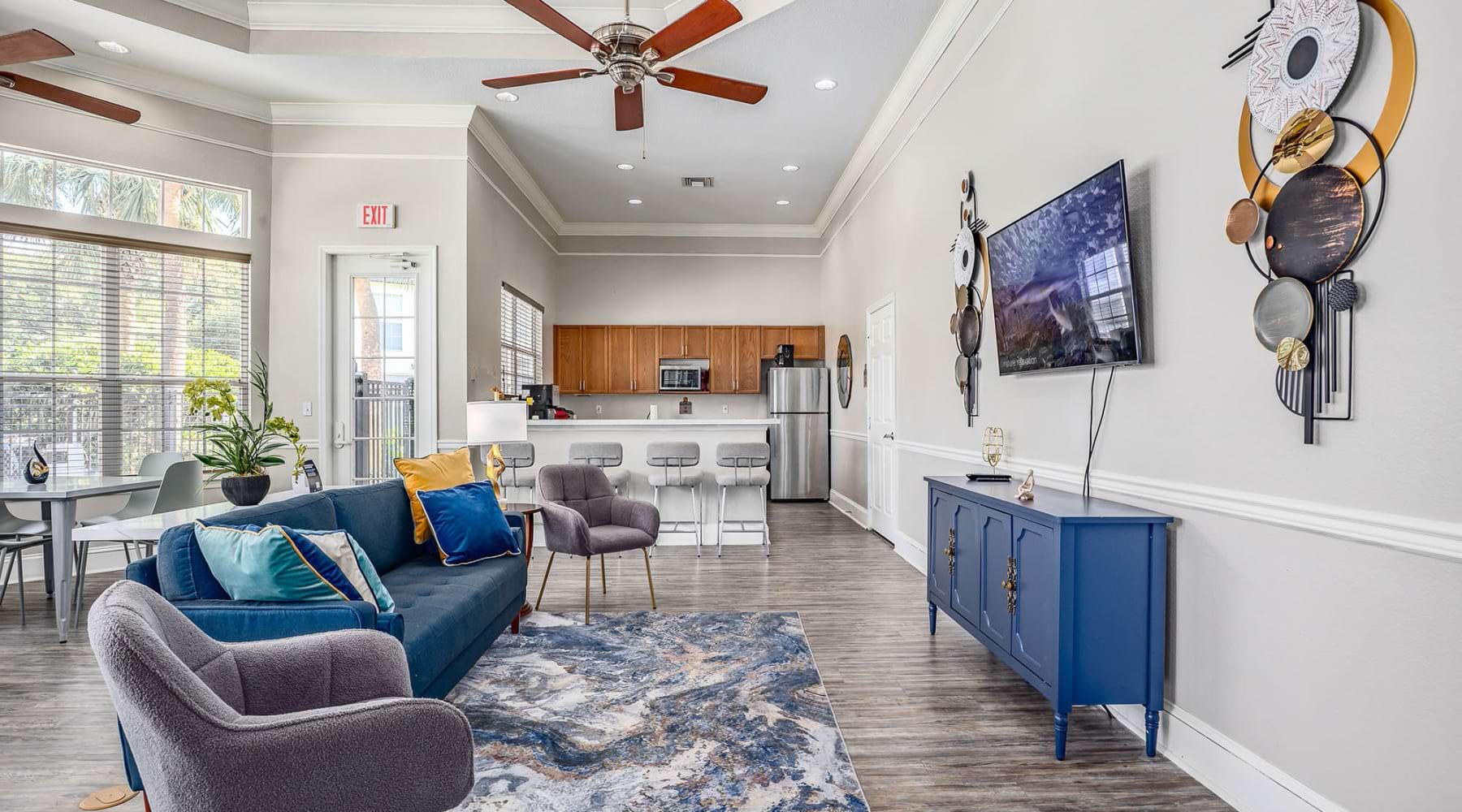a clubroom with couch chairs and wall mounted tv