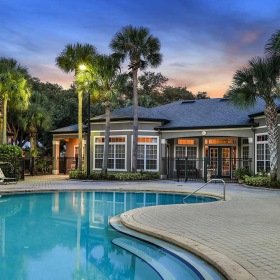 a swimming pool in front of a clubhouse